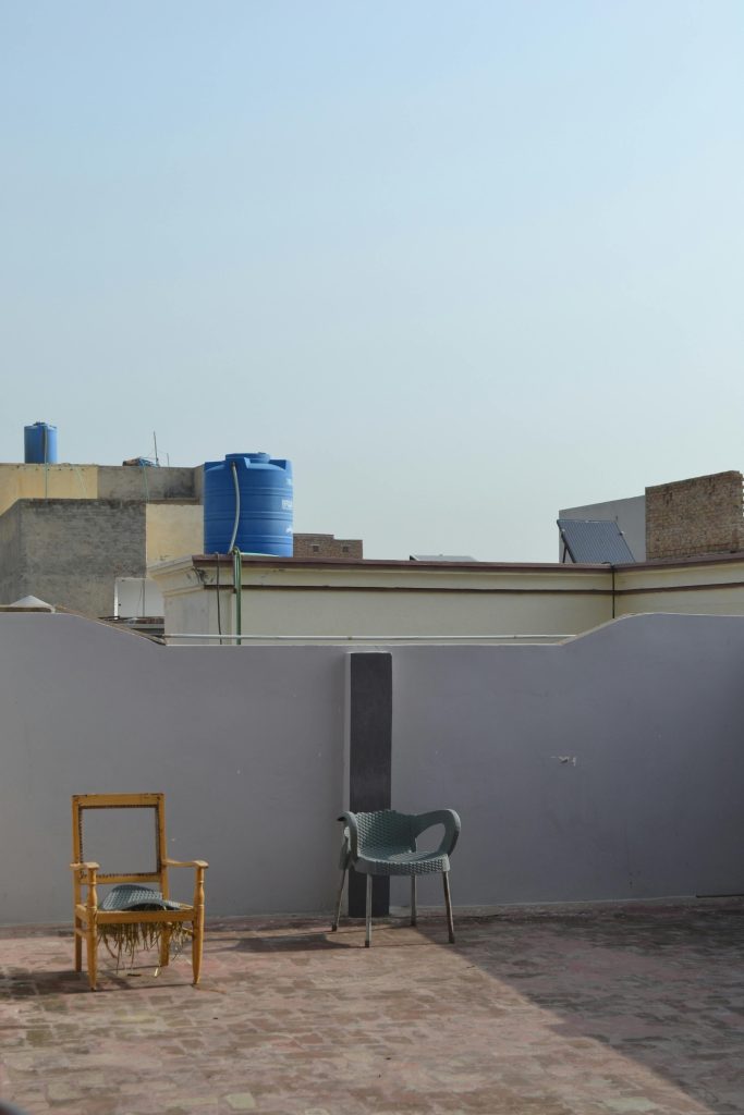 A quiet rooftop with empty chairs under a clear sky, showcasing urban architecture.